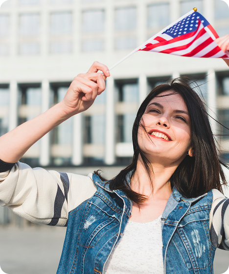 Happy immigrant celebrating U.S. visa approval while holding the American flag