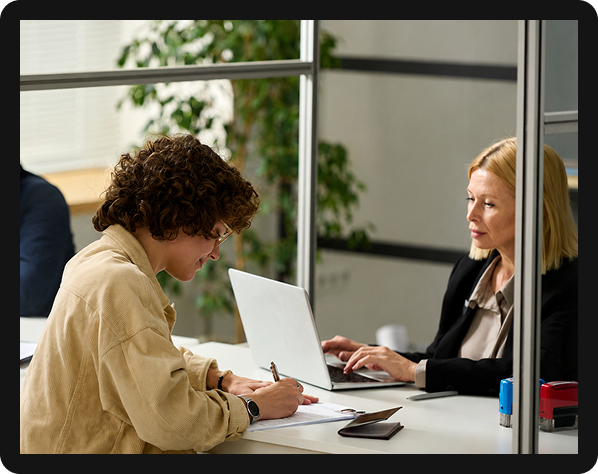 Immigration client signing legal documents during consultation with attorney in office