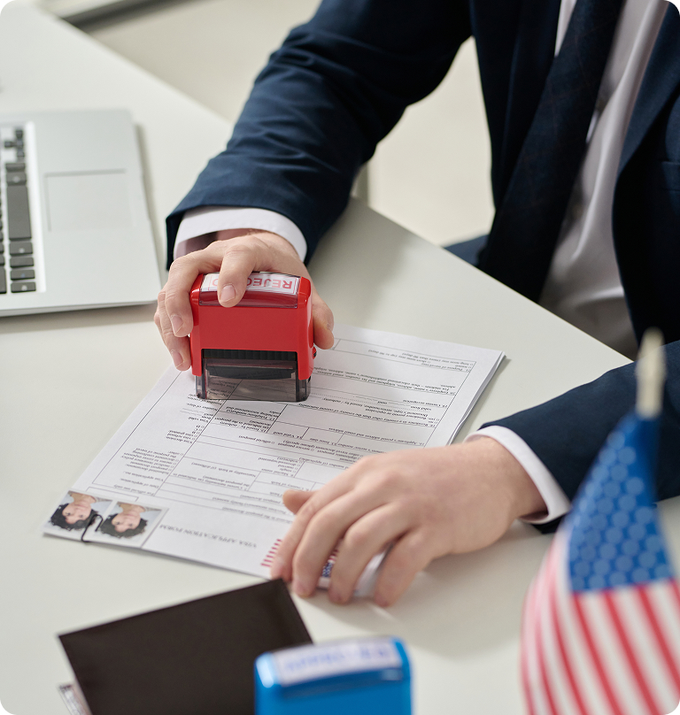 Immigration officer processing U.S. visa application documents with official approval stamp