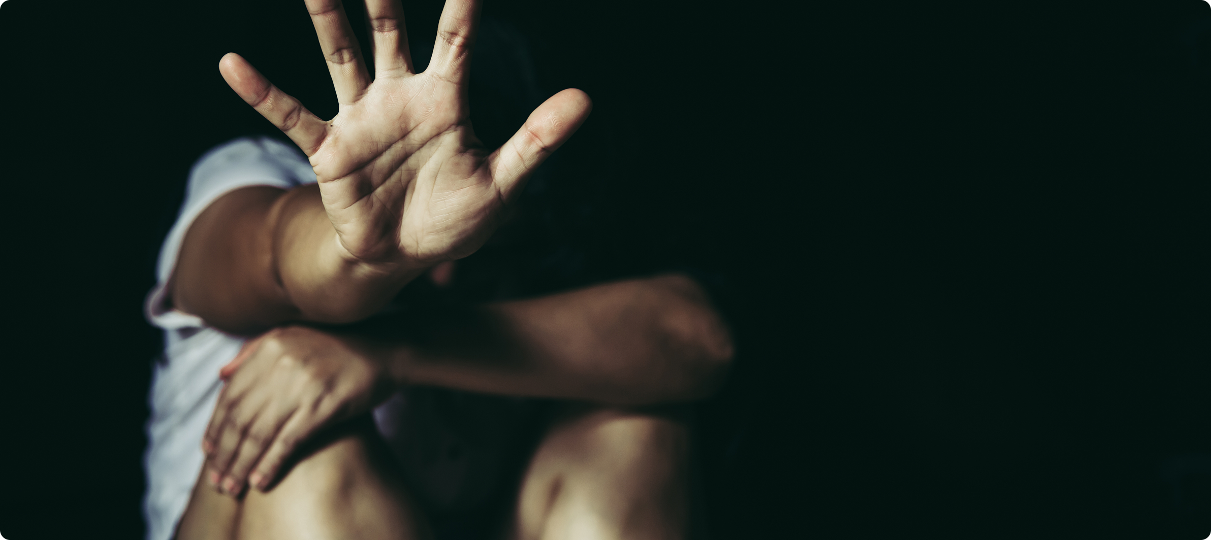 Person signaling stop gesture representing abuse, deportation defense, or legal protection