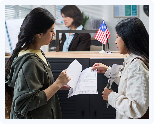 Clients submitting immigration documents at a visa office with an immigration consultant assisting the application process.