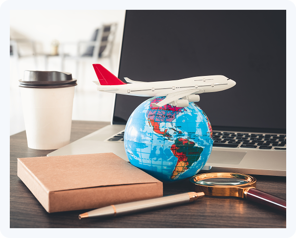 Airplane model on a globe with a laptop representing international travel, visa processing, and immigration services.